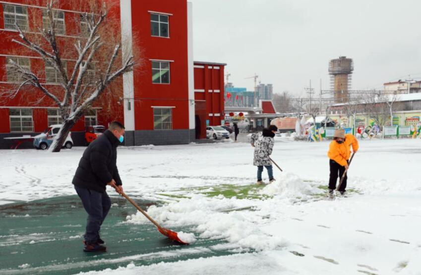 一双布满了老茧的手拿着扫帚在扫着雪.jpg